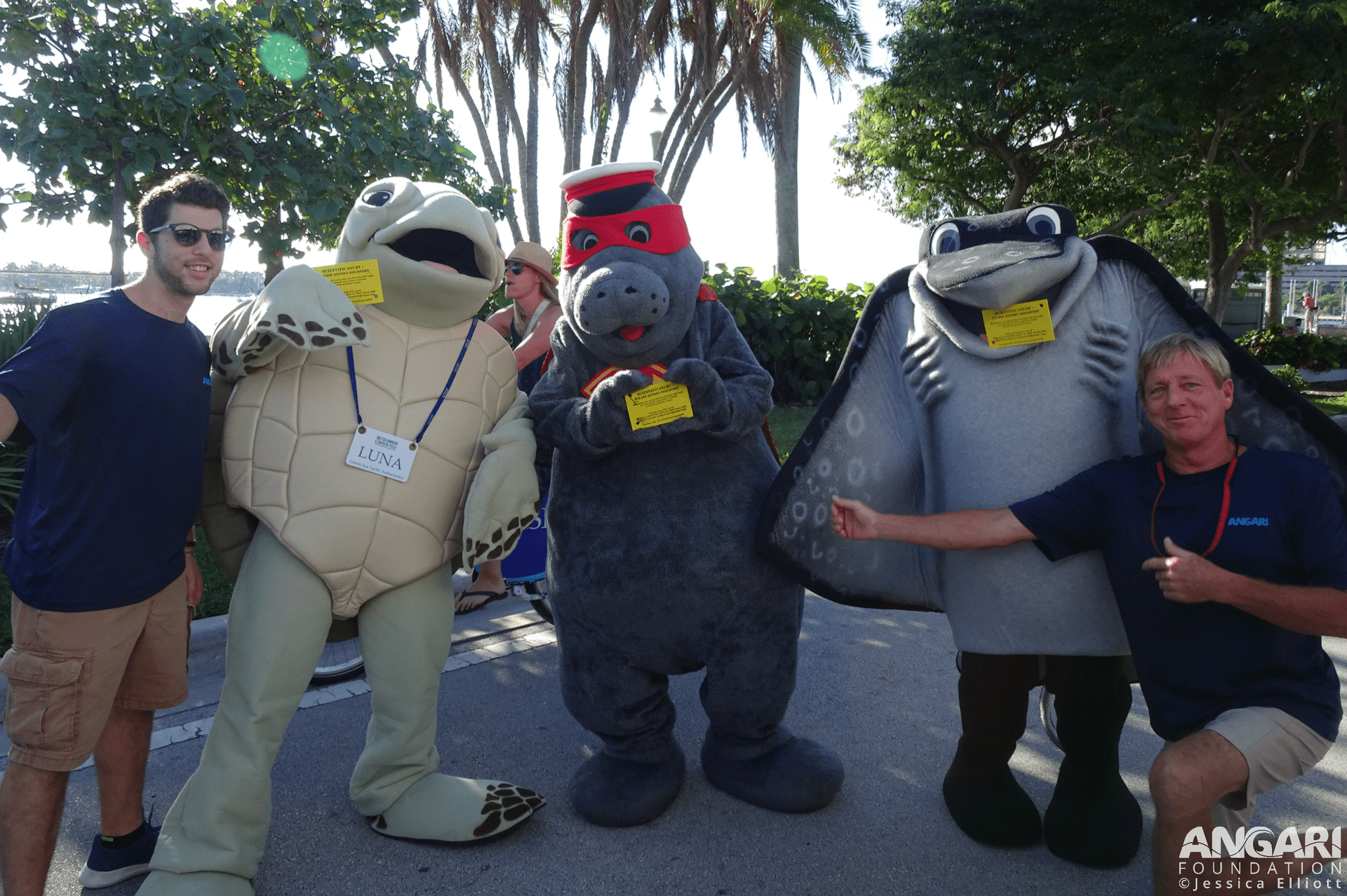 ANGARI Foundation And Some Mascot Friends Hold Drift Cards And Pose For A Photo