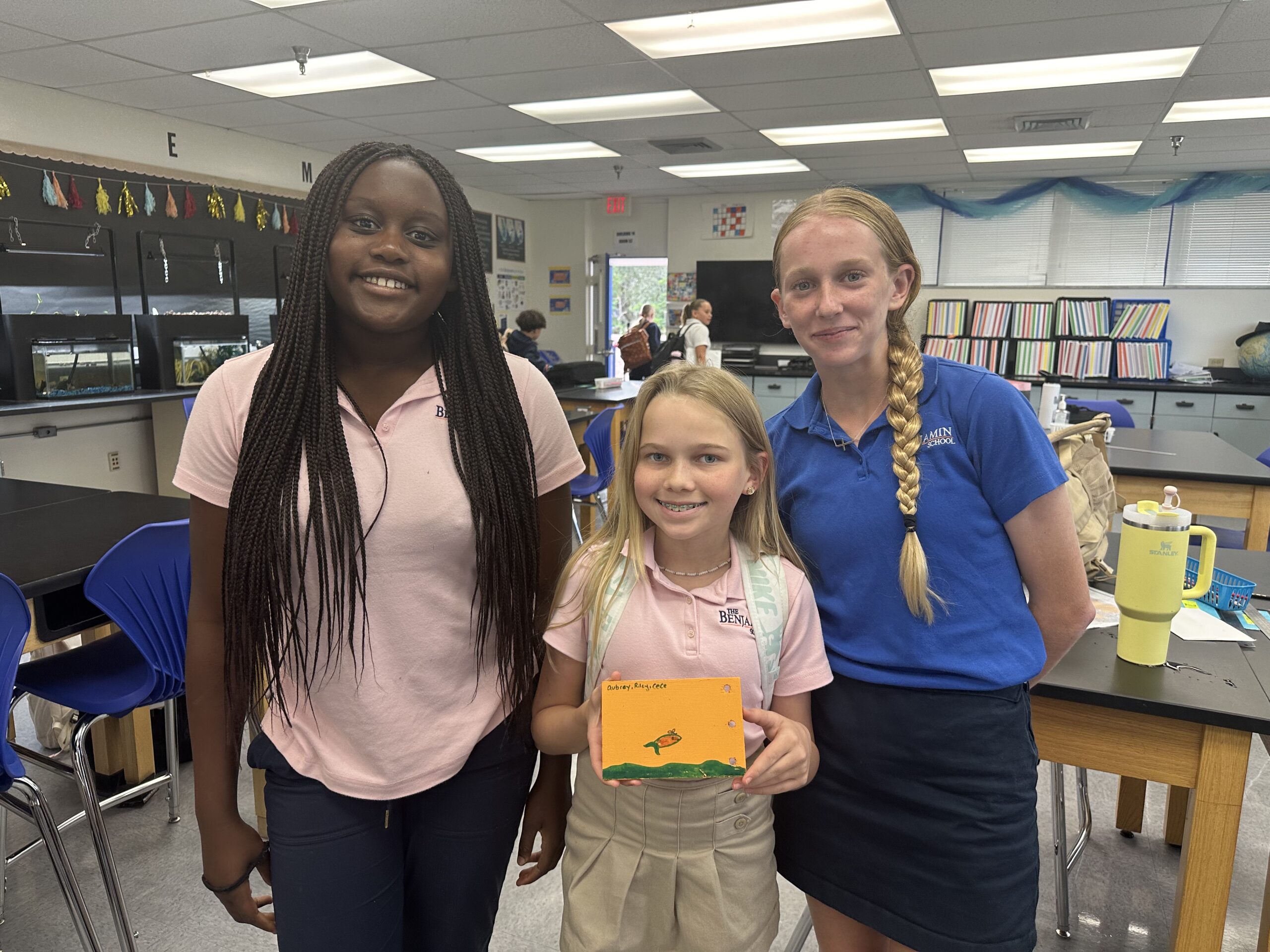 Students from The Benjamin School, who are involved in the creation of the new deployment site, proudly hold up their decorated Lagoon Drift card.