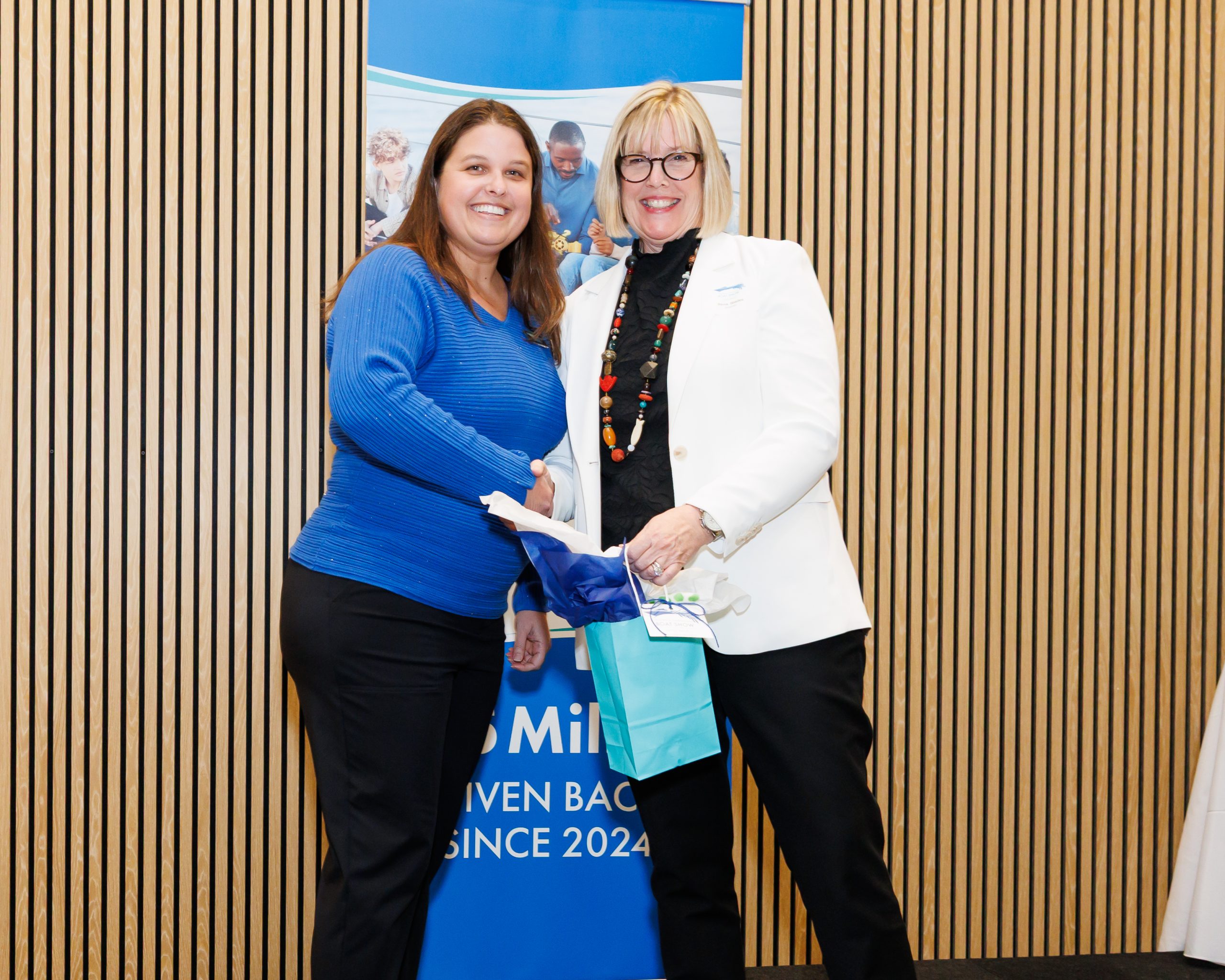 Angela Rosenberg accepts the PBIBS Gives Back grant from Rena Blades.